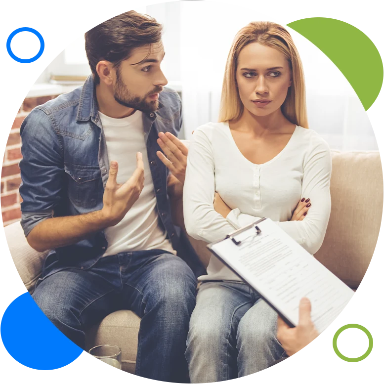 At the psychologist. Beautiful young couple is sitting on couch and hugging while doctor is making notes